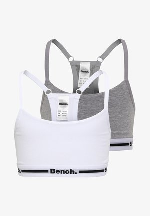 Zwei Sport-BHs: einer in Weiß und einer in Grau. Beide haben dünne Träger, ein einfaches Design und ein schwarzes "Bench."-Logo entlang des unteren Bands.