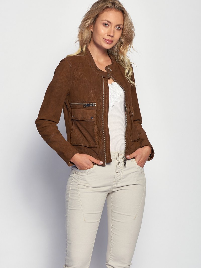 Bruin suède jasje met ritszakken, een ronde halslijn en een getailleerde pasvorm, gecombineerd met lichtgekleurde, slim-fit jeans.