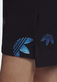 Svarta shorts med blanka blå blommönster och ränder. Tyget är glatt och har sidofickor för ökad rörlighet.