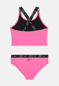 Rosa athletic bikini-set med svart innside. Topp med kryssede stropper med Nike-logo; bunnen har en merket svart midjebånd.