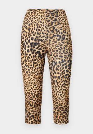 Leggings imprimés léopard en matériau extensible, longueur mi-mollet, avec des taches noires contrastantes sur un fond beige.