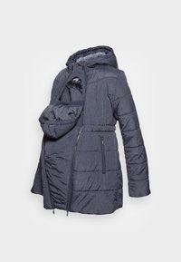 Mörkblå puffjacka med en avtagbar frampanel för bärande av bebisar. Vatterat mönster, fleecefoder i huvan och dragkedjefickor. Mjuk yttre textur.