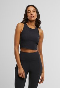 Svart avkortet tank topp laget av elastisk materiale, med høy hals og ermeless design. Jevn tekstur uten synlige mønstre.