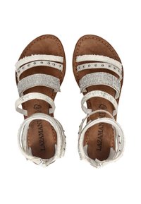 Brown sole sandals with white straps, featuring rhinestones, metal studs, faux fur trim, and ankle buckle closures.