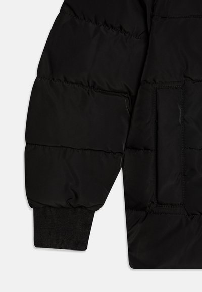 Black padded jacket sleeve featuring a textured finish, ribbed cuffs, and a single patch pocket on the forearm. Soft, insulated material.