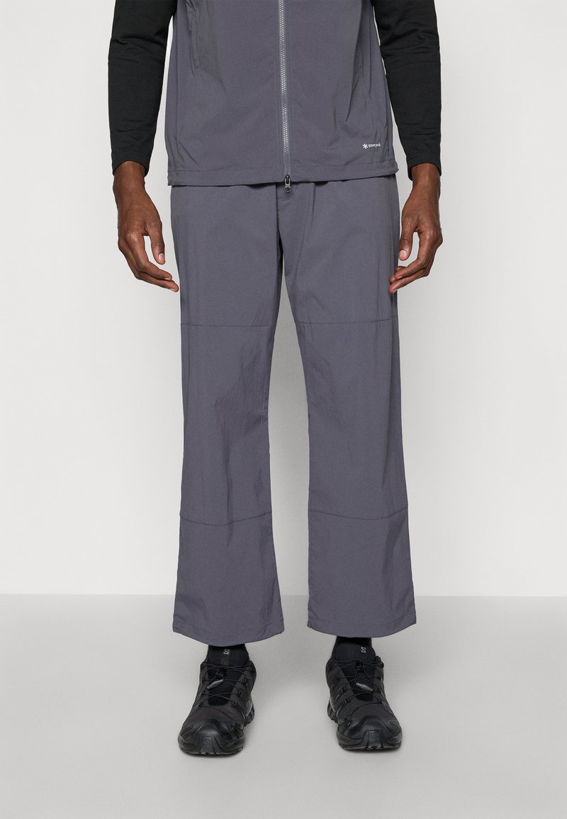 Gray, lightweight, moisture-wicking pants with a relaxed fit, featuring stitched panel details and worn with black athletic shoes.