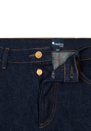 Donkerblauwe spijkerbroek met een Faguo-label, twee gouden knopen, gele stiksels en een zichtbare voorzak met een onderscheidende structuur.