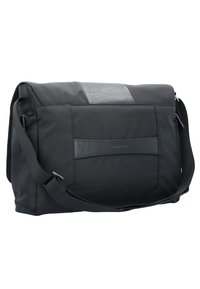 Borsa a tracolla nera con un design in tessuto testurizzato e un accento in pelle liscia. Presenta una lunga tracolla regolabile e una chiusura con zip.