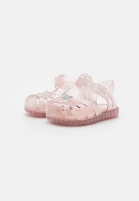 Sandalias de gel translúcidas rosas con purpurina, que presentan múltiples diseños recortados, una correa ajustable y una pegatina decorativa en el lateral.