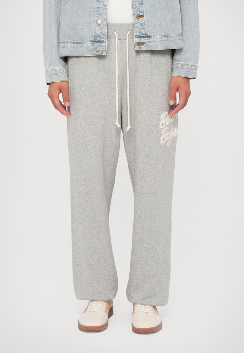 Gray sweatpants made of soft fabric, featuring a relaxed fit, adjustable drawstring, and a logo in white on the left side.