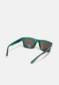 Ochelari de soare verzi translucizi cu lentile închise, design cu rame pătrate și brațe elegante, având un accent argintiu aproape de balamale.