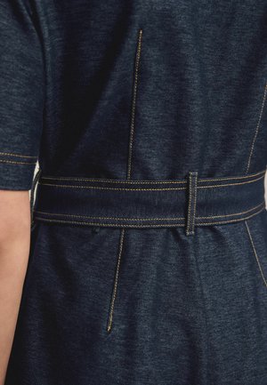 Denim dress with a fitted waist, rear belt detail, and yellow stitching. Dark blue fabric exhibits a subtle texture and tailored shape.