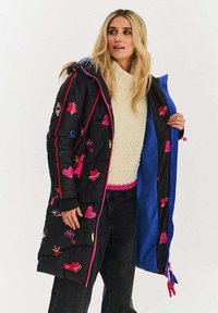 Černý péřový kabát s barevnými vyšívanými motivy, růžovým lemováním a modrou podšívkou, s dlouhou délkou a nastavitelným šňůrkováním.