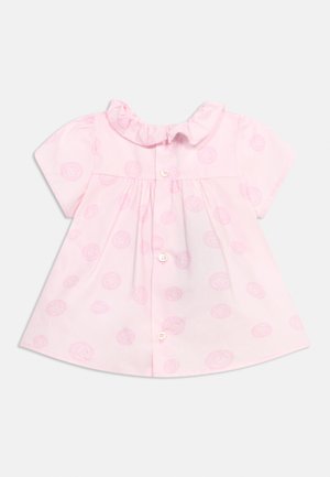 Hele roosa lühikeste varrukatega beebikleidi, millel on volditud krae, nööpidega esikülg ja kangas, millel on õrn ringikujuline muster.