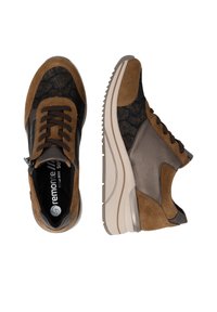 Paire de baskets marron et noir à lacets avec panneaux en daim et cuir, semelles blanches épaisses et fermeture éclair latérale sur fond blanc.