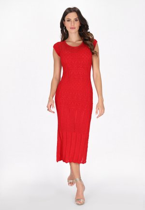 Abito rosso lavorato a maglia con silhouette aderente, maniche corte a campana e texture decorata. La lunghezza arriva fino al polpaccio con orlo scallop.