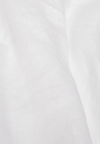 Weißer Stoff mit glatter Textur, der subtile Variationen in der Helligkeit und leichte Falten zeigt, was auf ein leichtes Material hindeutet.