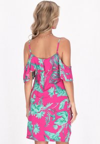 Abito floreale off-shoulder di un vivace rosa, caratterizzato da grandi motivi a foglia teal. Realizzato in un materiale leggero con un design fluido.