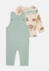 Completo per bambini composto da due pezzi: una salopette verde menta con una texture e bottoni, abbinata a una maglietta a maniche lunghe di colore crema con motivi di animali.