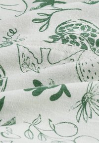 Katoenen stof met een groen botanisch patroon op een lichtcrème achtergrond, met een zachte textuur en ingewikkelde bladvormen en bloemenontwerpen.