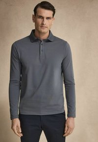 Pikétröja med långa ärmar i mörkgrått, tillverkad av slät tyg med krage och treknapppat knäppning, matchad med mörka byxor.