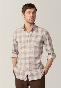 Camisa de manga larga para hombre en un patrón de cuadros en marrón claro, confeccionada en una tela suave, con cuello abotonado y mangas remangadas.