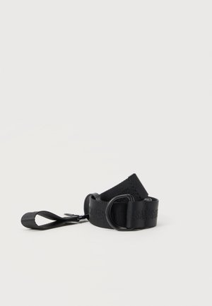 Black adjustable strap with D-ring buckle and looped end, made of woven fabric, laid coiled on white background.