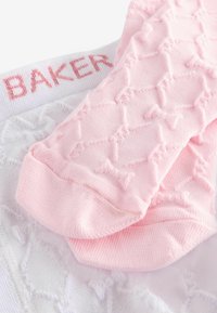 Calze rosa con motivo a fantasia e design di fiocchi testurizzati, abbinate a una base bianca con la scritta "BAKER" in lettere rosa sulla vita.