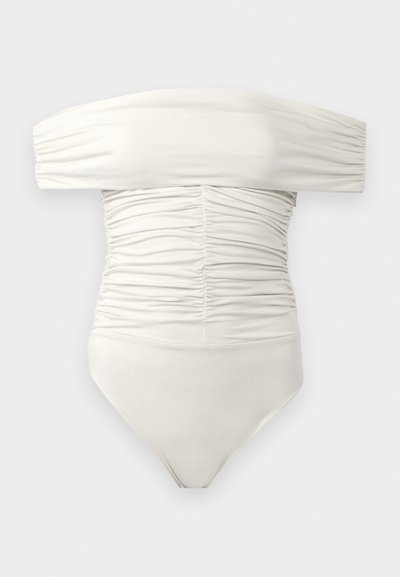 Balts off-shoulder ruched bodysuit ar garām šūņaino piedurkņu  un pieguļošu siluetu uz vienkārša fona.