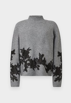 Pull en tricot gris avec col et ourlet côtelés, orné d'appliqués en dentelle florale noire le long du bas, des manches et des poignets.