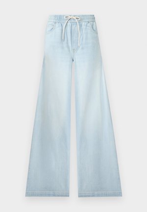 Pantalon en denim bleu clair à jambes larges, taille élastique avec cordon blanc, poches avant et sans fermetures visibles.