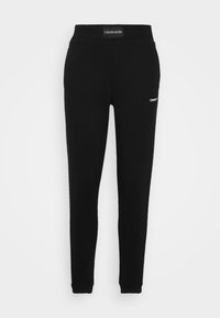 Black Calvin Klein joggers with elastic waistband, slim tapered legs, and small white logo on the upper thigh and waistband.
