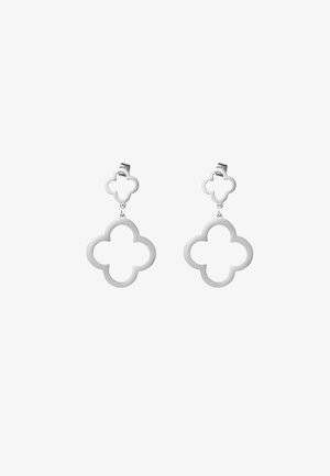 Boucles d'oreilles en métal argenté avec un design floral en quatre-feuilles. Présentent un motif découpé et un système de clip pour un port facile.