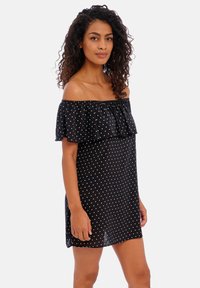 Vestido preto sem alças com bolinhas brancas, camada superior de babados fluida, tecido leve e corte descontraído.