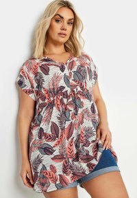 Camiseta de manga corta en tejido ligero con un patrón floral de hojas rosas y navy sobre un fondo blanco, con un corte holgado y escote en V.