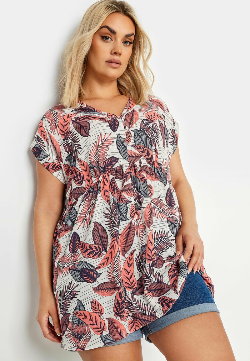 Camiseta de manga corta en tejido ligero con un patrón floral de hojas rosas y navy sobre un fondo blanco, con un corte holgado y escote en V.