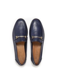 Mocasines de piel azul marino con un acabado suave, detalle de estribo dorado y plantilla acolchada en tonos beige. Punta redonda y diseño fácil de poner.
