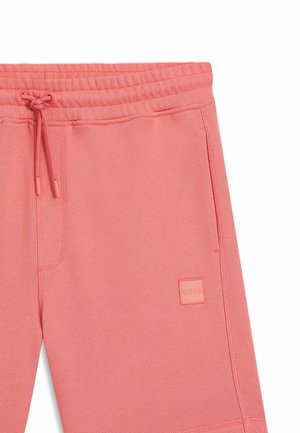 Pantaloncini rosa con coulisse, vita elastica, tasche anteriori e una piccola toppa quadrata con logo sulla gamba destra.