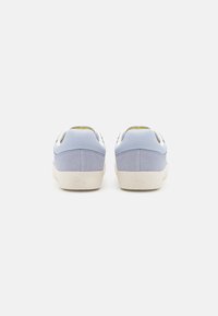 Zapatillas deportivas de color azul claro, hechas de cuero y ante, con una suela de goma blanca, un diseño limpio y un panel trasero texturizado.