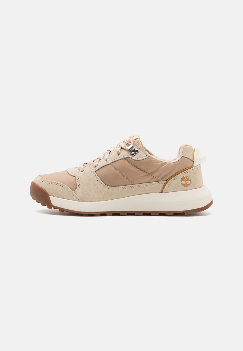 Light beige sneakers with a combination of smooth and suede textures, a round toe, and a rubber outsole featuring a textured grip.