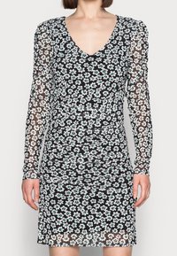Kleid mit Blumenmuster auf schwarzem, transparentem Grund, versehen mit grünen und weißen Blumen, langen Ärmeln und einem V-Ausschnitt. Mit strukturiertem Raffung-Detail.