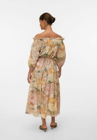 Robe florale mi-longue avec encolure décolletée, manches froncées et jupe à volants. Le tissu présente des couleurs pastel et des textures douces.