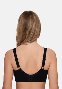 Black bra with wide straps, a seamless design, and adjustable features. Back closure with multiple hooks and fabric detailing along the edges.