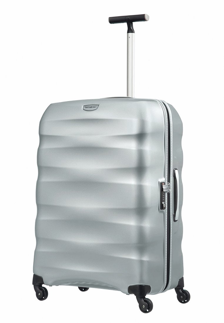 Valise rigide en argent avec une surface texturée en vagues, poignée télescopique et quatre roues pour une mobilité aisée. Elle dispose d'une fermeture éclair.