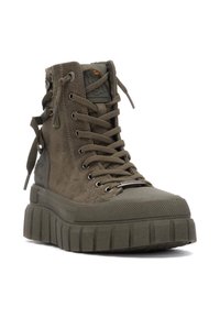 Zapatilla alta de color verde oliva con material de ante, suela gruesa y texturizada, punta redondeada, ojetes de metal y un diseño de cordones prominente.