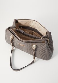 Borsa a tracolla grigia trapuntata con hardware dorato, una tracolla decorata con catena e un interno foderato con più scomparti e cerniere.