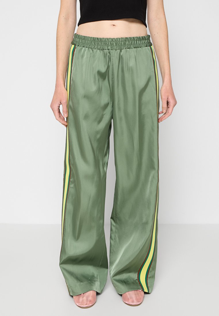 Grüne Satin-Hosen mit weitem Bein, einem elastischen Bund und vertikalen Streifen in Gelb, Grün und Rot an den Seiten.