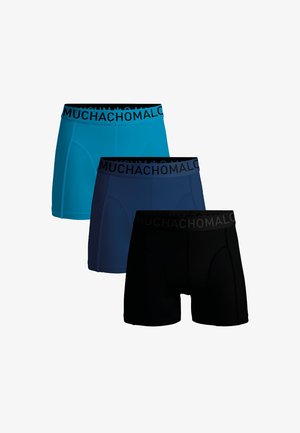 Tři páry boxerů v jasně modré, tmavě modré a černé barvě, s černým pasem označeným "MUCHACHOMALO". Hladká textilní struktura.