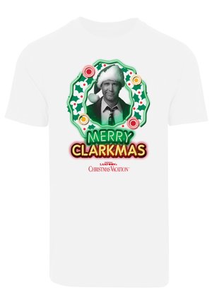 Fehér pamut póló, melyen egy Mikulás sapkás férfi grafikus ábrázolása látható, zöld koszorúval körülvéve, rajta pedig vastag betűkkel a "BOLDOG KALÁCSKÁT" felirat található.