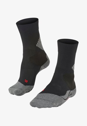 Chaussettes noires au niveau de la cheville avec des sections grises aux orteils et au talon, présentant un motif texturé et des accents réfléchissants. Logo rouge près de la zone des orteils.